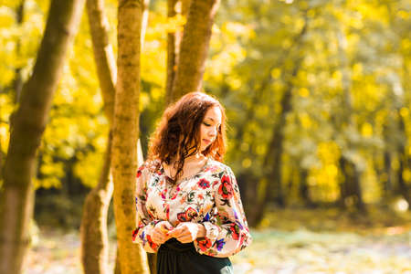 Portrait of beautiful young woman walking outdoors in autumnの写真素材