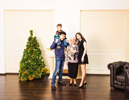 family, happiness, generation, holidays and people concept - happy family  sitting on couch....