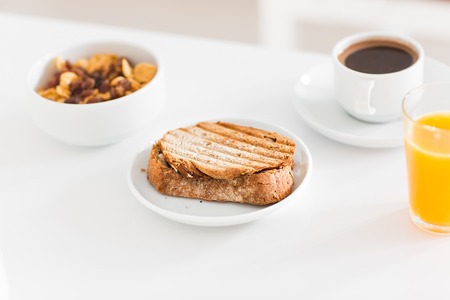 healthy breakfast meal - bowl of muesli with yoghurt ,  toast with jam and a glass of orange juiceの写真素材