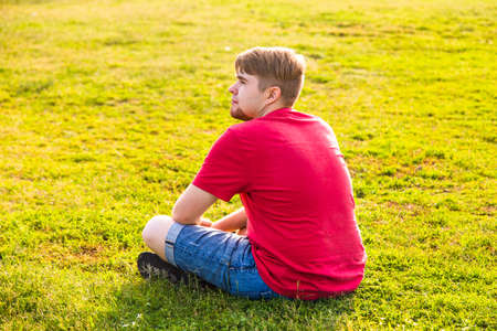 Man sitting on the grass and enjoying the nature.の写真素材