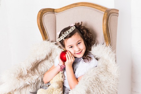 Cute  girl holding decorative red christmas  ball.の写真素材