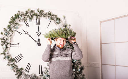 Happy funny male portrait with  Christmas wreath.