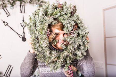 Happy funny male portrait with  Christmas wreath.の写真素材