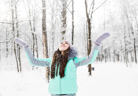 Happy young woman having fun in the snow.