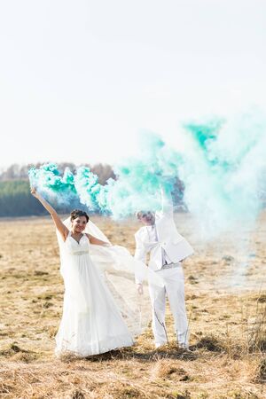 Wedding couple with blue smoke in the park.の写真素材