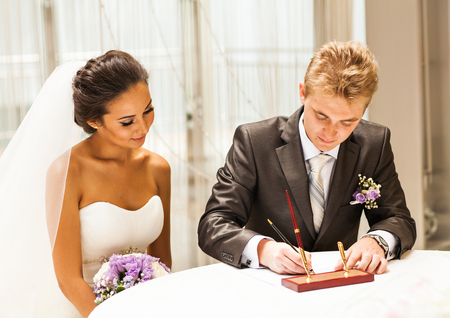 Bride signing marriage license or wedding contract.