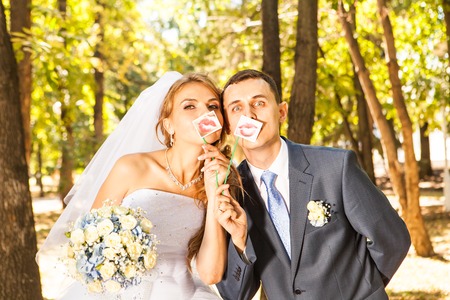 Wedding couple posing with stick lips, mask. Wedding accessoriesの写真素材