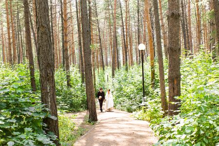 Young wedding couple walking together at park.の写真素材