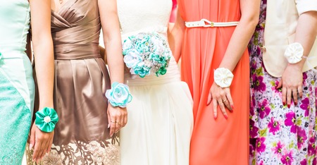 The bride and bridesmaids are showing beautiful flowers on their hands.の写真素材