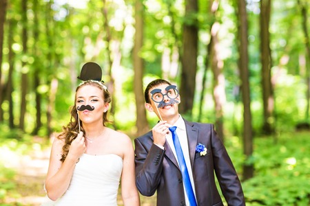 Wedding couple posing with stick lips, mask. April Fools' Day.の写真素材