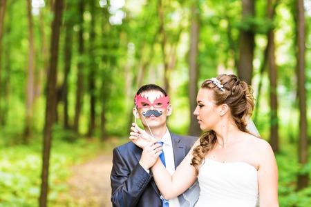 Wedding couple posing with stick lips, mask. April Fools' Day.の写真素材