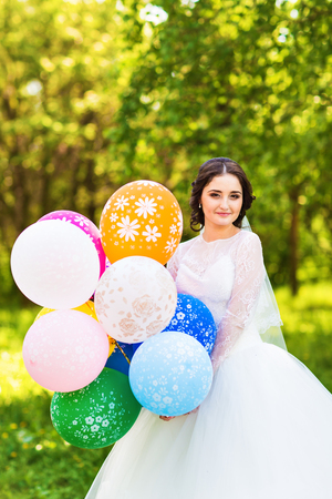 Beautiful young happy bride  with colorful balloonsの写真素材