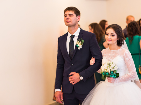Bride and groom are holding each other's hands during church wedding ceremonyの写真素材