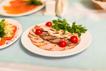 smoked ham with cherry tomatoes  on the table.の写真素材
