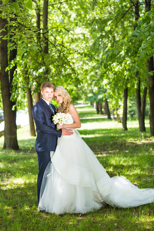 Happy bride and groom in park summer  outdoor.の写真素材