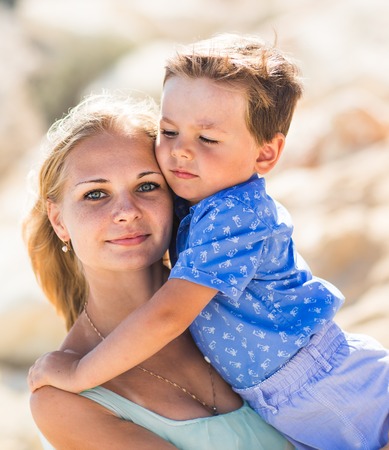 Beautiful young mother holds a little son.の写真素材