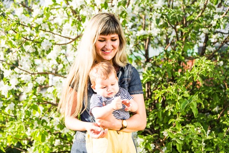 Happy woman and child with beautiful spring flowers against green background. Family holiday concept. Mothers dayの写真素材