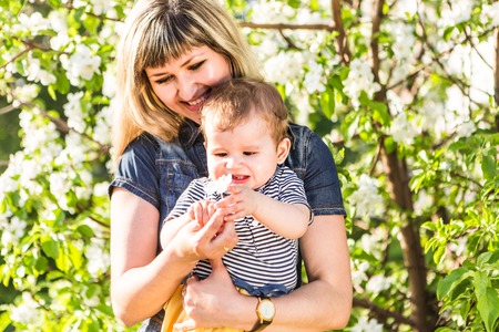 Happy woman and child in the blooming spring garden.Mothers day holiday concept.の写真素材
