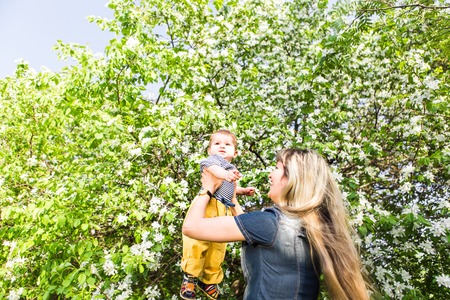 Happy woman and child in the blooming spring garden.Mothers day holiday concept.の写真素材