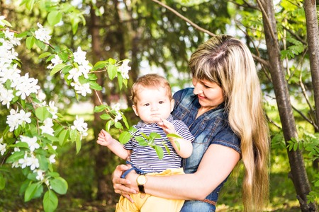 Happy woman and child with beautiful spring flowers against green background. Family holiday concept. Mothers dayの写真素材