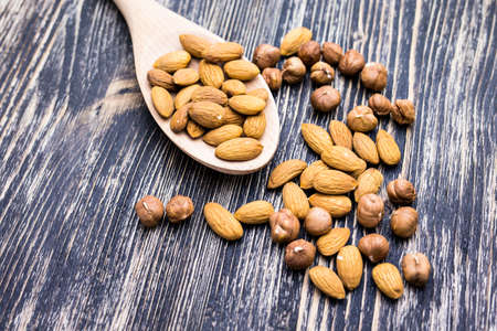 Almonds on wooden background. Almonds in spoonの写真素材