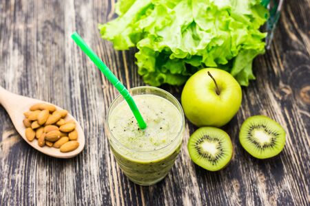 Healthy green smoothie with kiwi and apples on  wooden background.の写真素材
