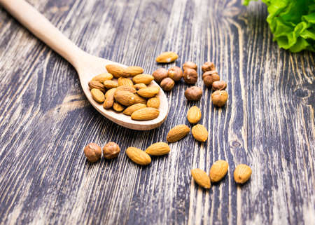 Almonds on wooden background. Almonds in spoonの写真素材