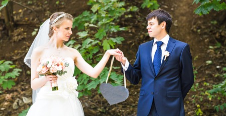 A bride and groom holding a heart shaped  signの写真素材