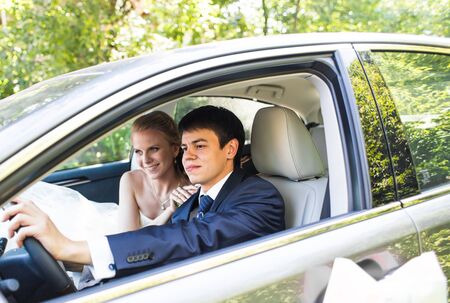 Bride and groom inside a  car. They are happyの写真素材