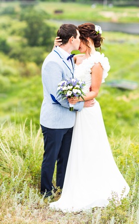 wedding pair hugging and kissing at the gateの写真素材