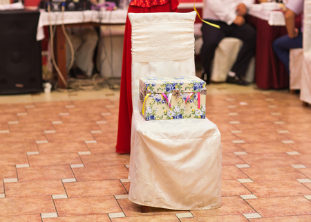 Wrapped gift boxes with ribbons as Christmas presents on a chairの写真素材