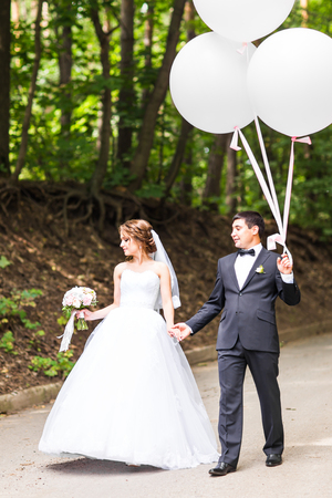 summer holidays, celebration and wedding concept - couple with colorful balloons and engagement ringの写真素材
