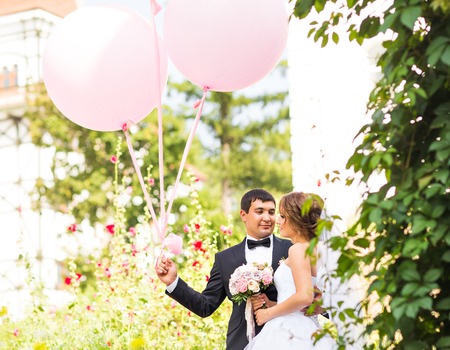 summer holidays, celebration and wedding concept - couple with colorful balloons and engagement ringの写真素材