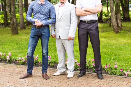 Three friends, groom with groomsman having fun.