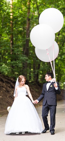 summer holidays, celebration and wedding concept - couple with colorful balloons and engagement ringの写真素材