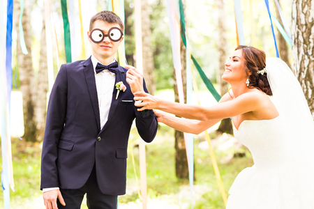 April Fools' Day. Wedding couple have fun with maskの写真素材