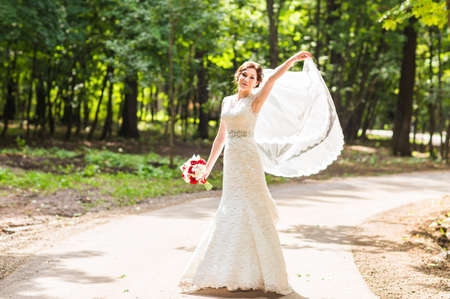 Beautiful bride with bouquet of flowers outdoor.の写真素材