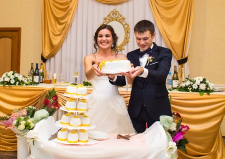 Wedding ceremony. Bride and groom cutting cakeの写真素材