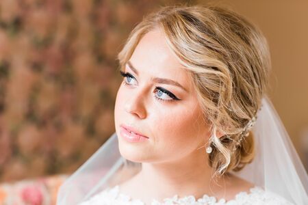 Beautiful bride in white wedding dress with bridal bouquetの写真素材