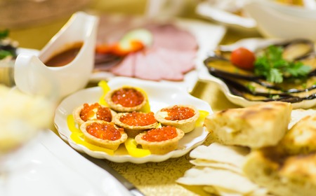 Red caviar in tartlets on white plate close-up