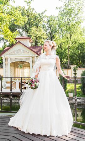 Beautiful bride with bouquet of flowers outdoor.の写真素材