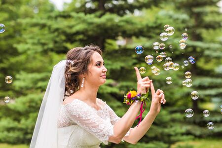 Young bride play with soap-bubble and joy smile.の写真素材