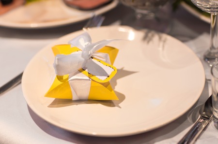 Close-up of bonbonniere on the table. Yellow Bonbonniere on the plateの写真素材