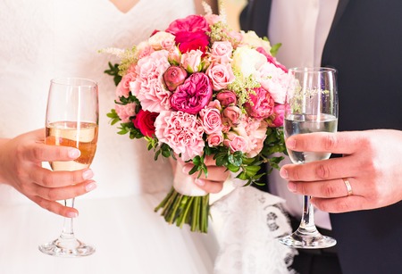 Bride and groom with glasses of champagne close-up.の写真素材