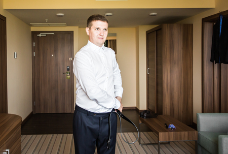 Man puts on brown belt. businessman getting readyの写真素材