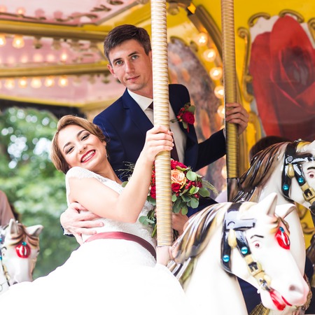 Bride and groom on carousel. Wedding dayの写真素材