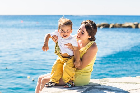 mother and son playing on the beach.の写真素材