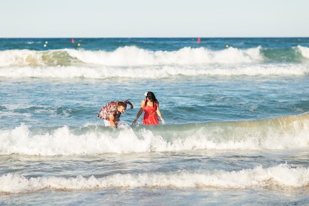 happy young couple having fun, man and woman in the sea on the beach.の写真素材