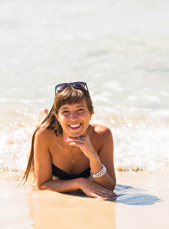 young beautiful girl in white swimsuit bikini posing on beach in sunlight, fashion model, straight hair,Sunny portrait,outdoor fashion style,close up,Miami beach,leather tanning,fitness figure,の写真素材