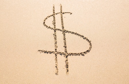 dollar sign on the sandy sunny beach.の写真素材